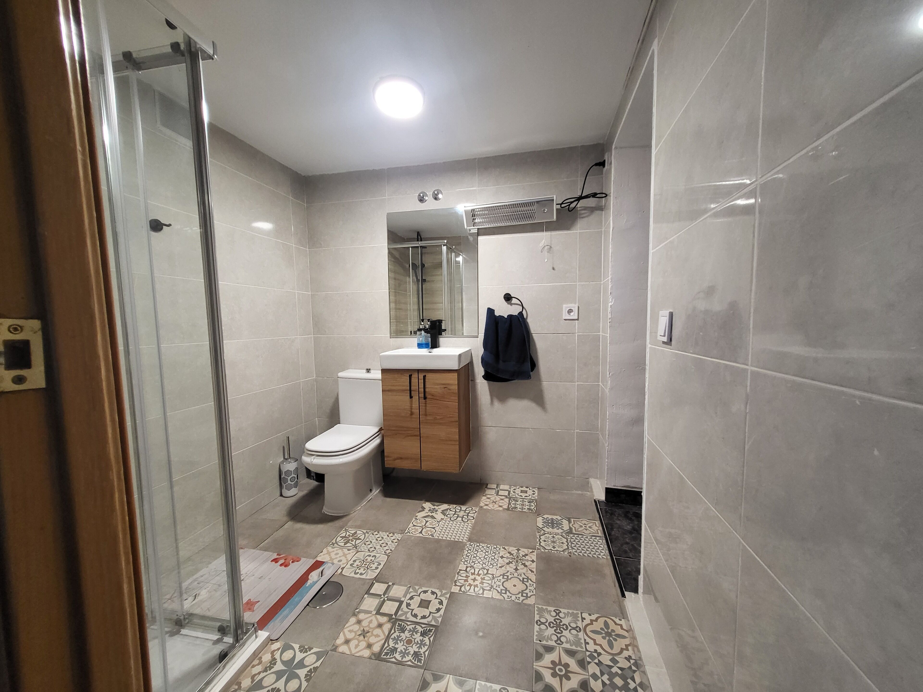 Un baño con inodoro, lavabo y zona de ducha.