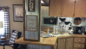 Une cuisine avec un plan de travail en bois, un évier et un panneau décoratif accueillant.