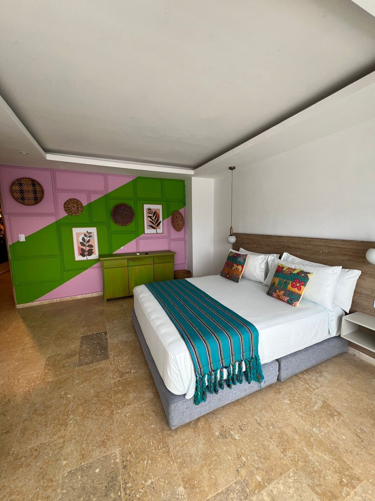 A modern bedroom with a bed, a dresser, and a wall with decorative plates.