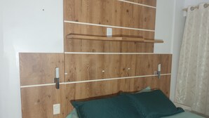Una camera da letto con una testiera in legno, un letto con lenzuola color acquamarina e un comodino.