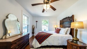 A bedroom with a bed, dresser, mirror, ceiling fan, and bedside lamps. - The Charmer, Super Close to UT + Downtown (Austin)