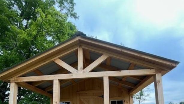 A wooden cabin with a porch, a door, and windows. - Enjoy nature in a cabin getaway, wildflowers, lush fields and maple woods trails (Cambridge)