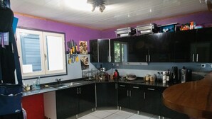 Una cocina con armarios negros, una ventana y diversos utensilios.