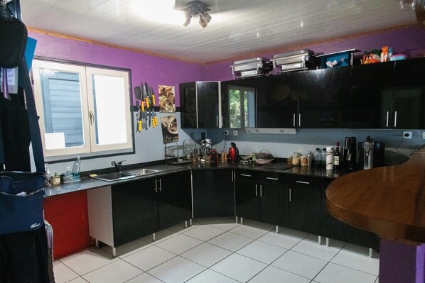 A kitchen with black cabinets, a window, and various kitchen items.