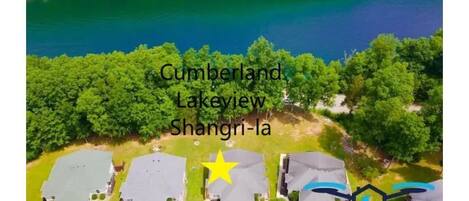 An aerial view of a residential area with houses, a lake, and a star symbol marking a specific location.