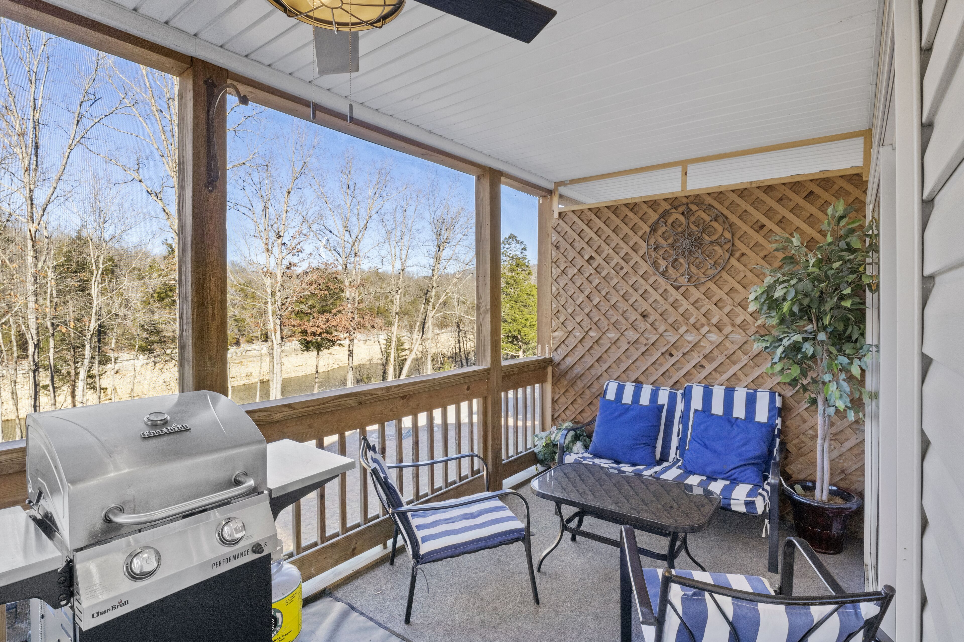 Une terrasse couverte équipée d’un barbecue, de chaises et d’une table.