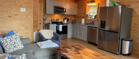 A compact kitchen with modern appliances, a dining area with a wooden table, and a cozy seating arrangement.