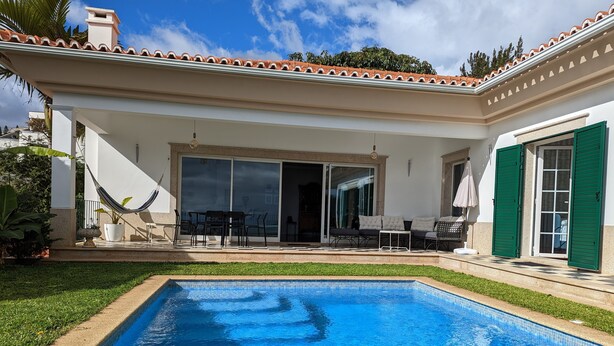 A swimming pool with a patio area, a hammock, and a covered seating area with a table and chairs. - Casa Roc Madeira | 5 Bedrooms | Ocean and City Views, Private Heated Pool (Funchal)