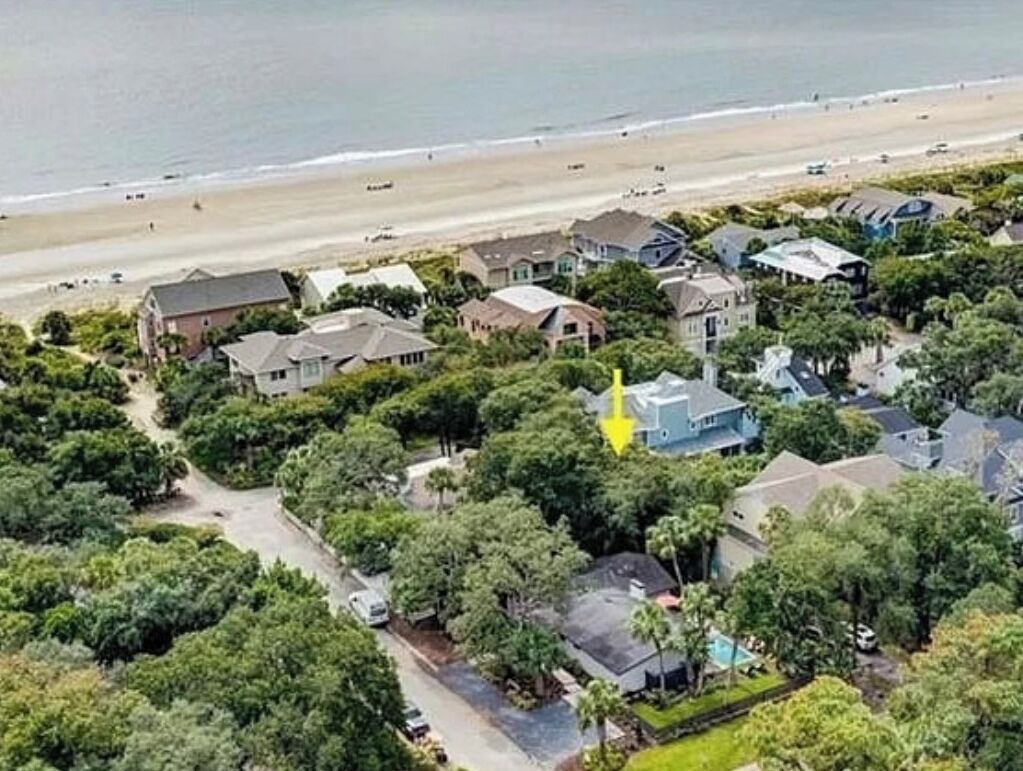 Vista aérea de una zona residencial costera con casas, una playa y una carretera.