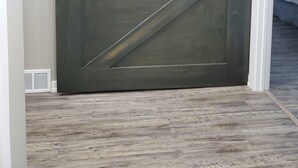Eine große, dunkle Metalttür im Scheunendesign in einem Flur.