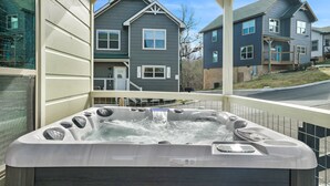 A hot tub with a control panel, surrounded by a balcony with a railing.