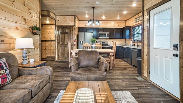 A cozy cabin interior with a wooden interior, a dining area, and a kitchen.