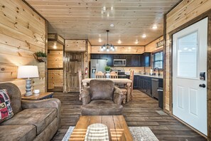 A cozy cabin interior with a wooden interior, a dining area, and a kitchen.