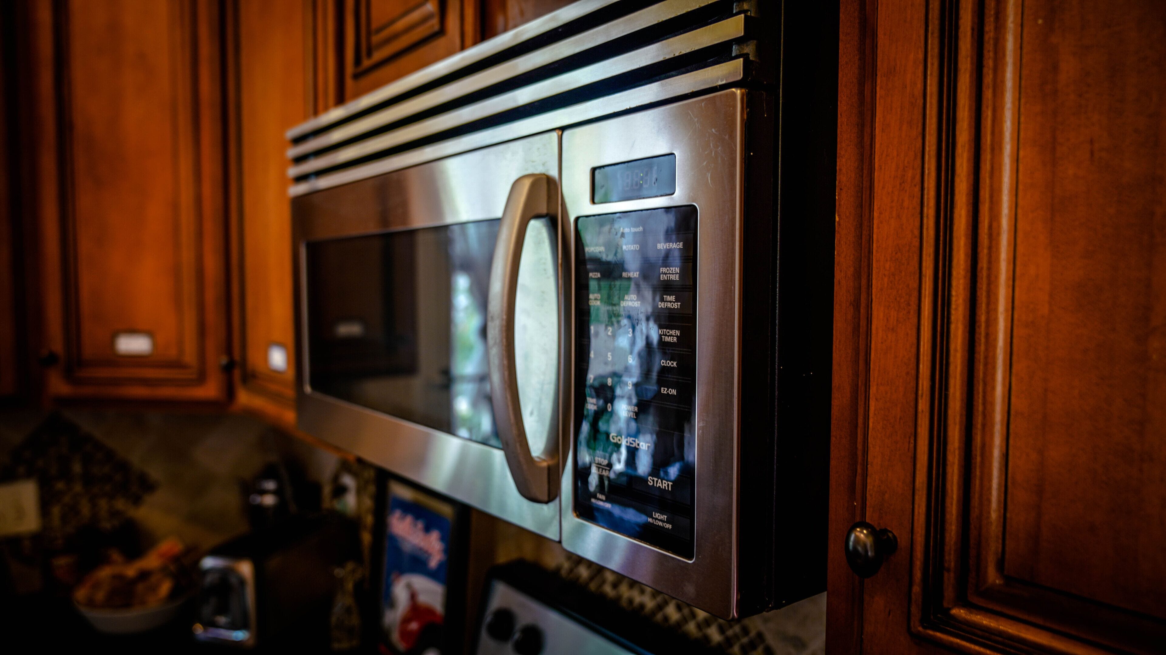 Een rvs magnetron met een digitaal display en verschillende kookstanden.