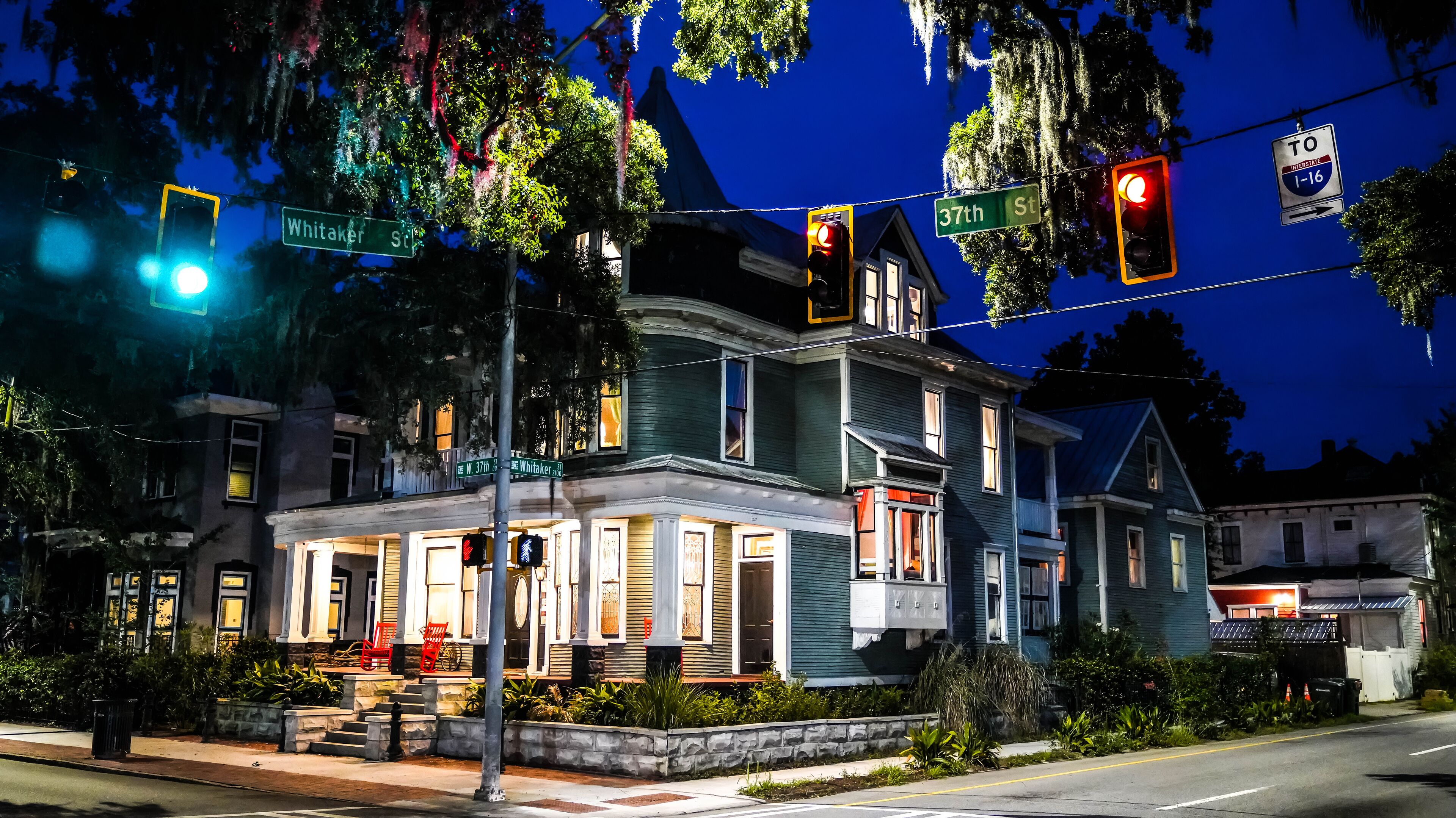 A historic house with a porch, a front yard, and a street sign indicating 37th St.