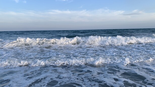 Una playa con olas rompiendo sobre la orilla.