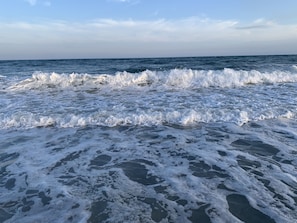 A beach with waves crashing onto the shore.