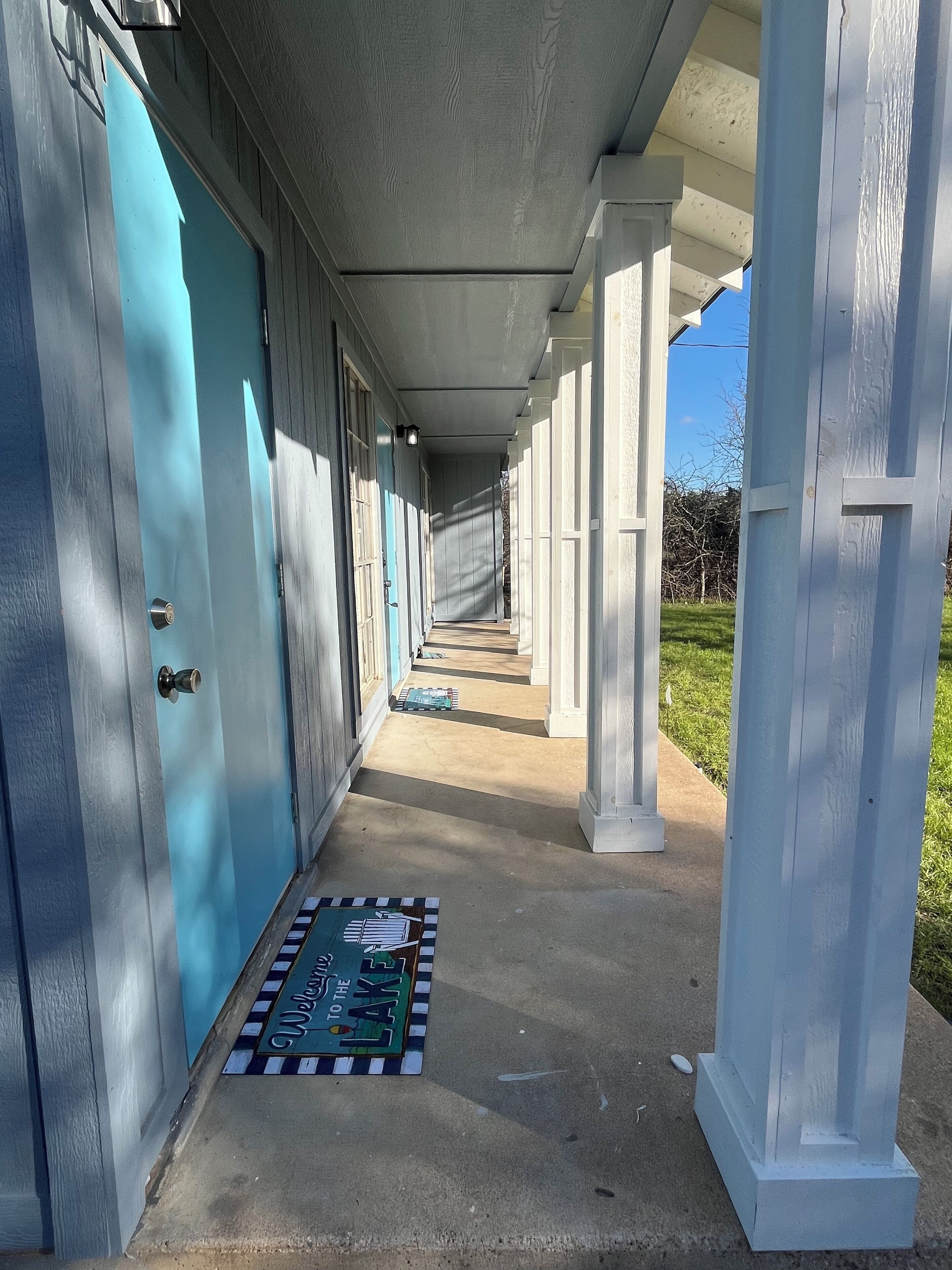 Un pasillo cubierto con una puerta azul y un felpudo.