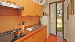 Eine Küche mit Holzausstattung, einem Herd, einer Spüle und einer Mikrowelle.