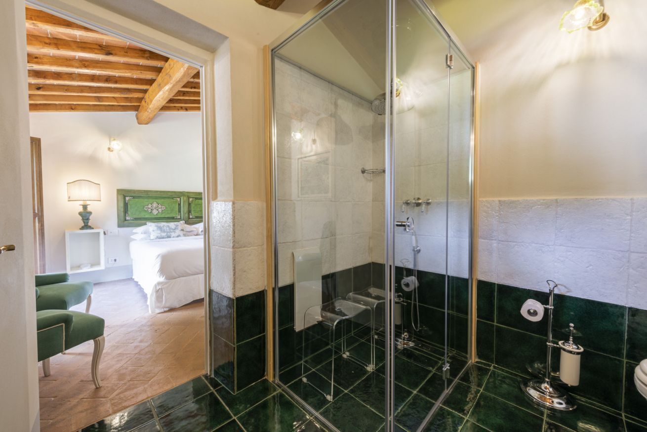 Une salle de bain avec une douche à parois de verre, des toilettes et un lavabo.