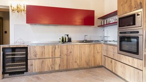 Una cocina moderna con armarios de madera, electrodomésticos de acero inoxidable y una pared de acento roja.
