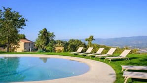 A swimming pool with lounge chairs, a stone building, and a view of the landscape. - Villa San Cresci by MMega (Vicchio)