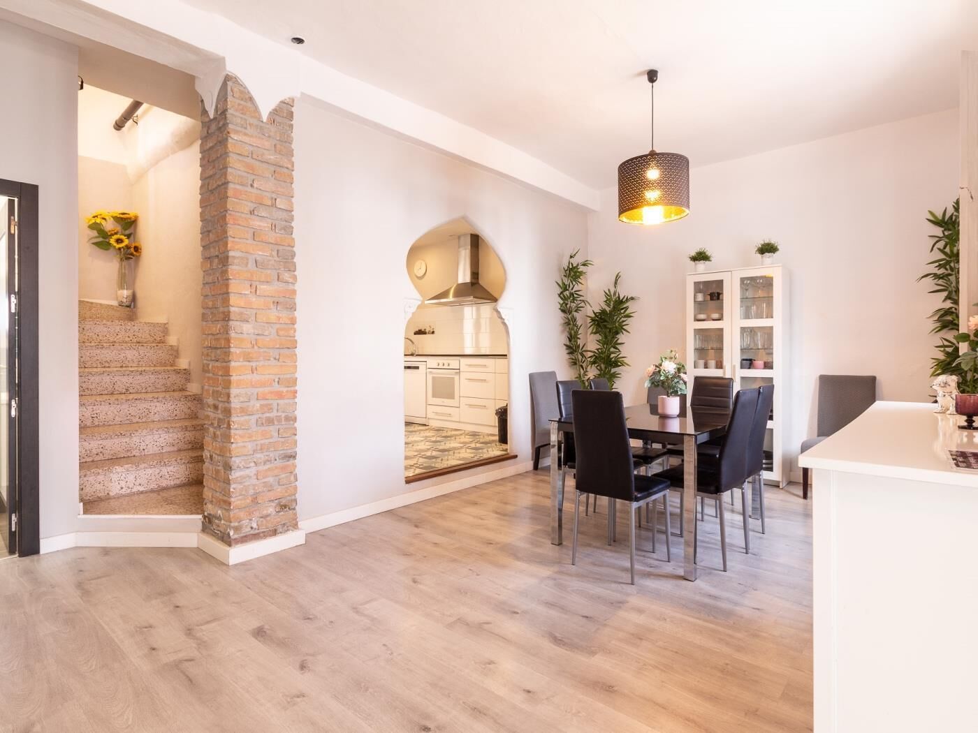 Un interior moderno con cocina, comedor y escalera.