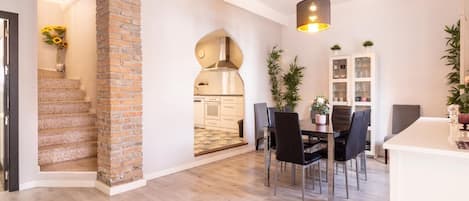 Un interior moderno con cocina, comedor y escalera.