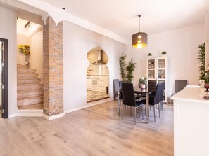 A modern interior with a kitchen, dining area, and staircase.