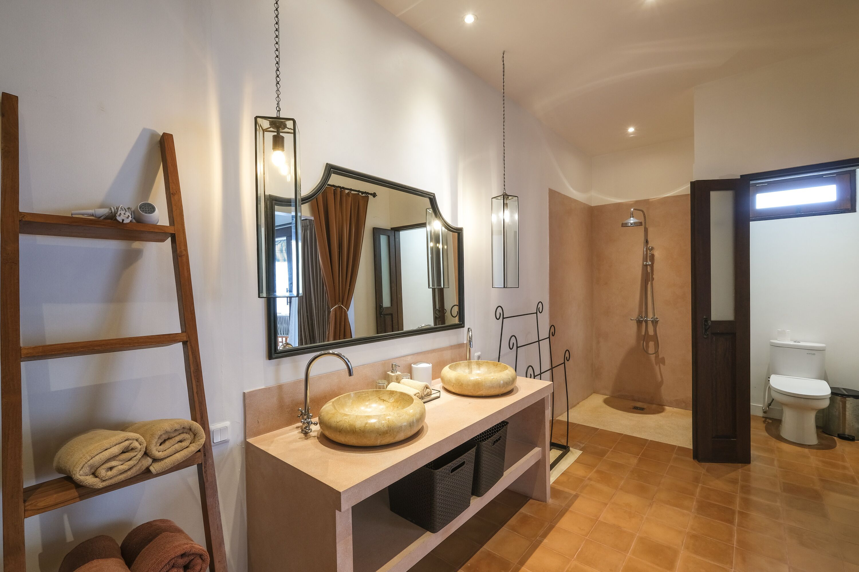 Un bagno moderno con due lavabi, una doccia e un water.