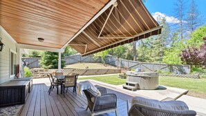 An outdoor patio with a wooden deck, a covered seating area, and a hot tub. - Yosemite, Hot Tub, Pets - Memories! (Oakhurst)
