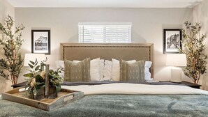A bedroom with a large bed, a headboard, two bedside tables with lamps, and framed pictures on the walls. - Yosemite, Hot Tub, Pets - Memories! (Oakhurst)