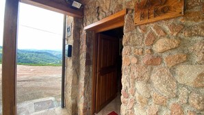 Une entrée en pierre, avec une porte en bois et une enseigne sur laquelle on peut lire « CASA KIKO ».
