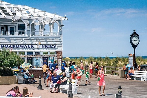 A boardwalk with a restaurant named 'Boardwalk Fries' and a clock. - Sea Colony 2 BR, Screened Porch, Steps to Pool, Pickleball, Tennis (Bethany Beach)
