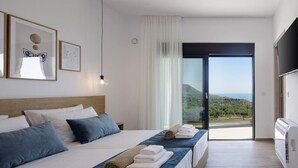 A modern hotel room with a large bed, a flat-screen TV, and a balcony with a view of the landscape. - Villa Empire Ultimate Luxury villa with heated pool (Kefalas)