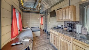 Een compact RV-interieur met een kitchenette, een zithoek en een hoogslaper.