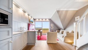 Een moderne keuken met een ingebouwde oven en een eethoek met een rood tapijt.