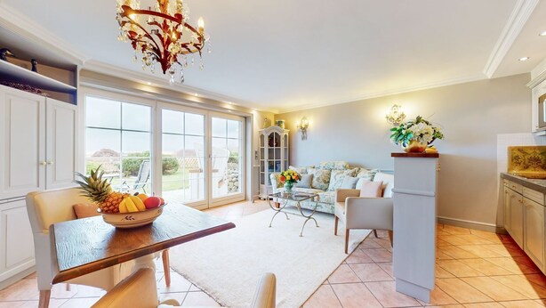A spacious kitchen with a dining area, large windows, and a view of the outdoors.
