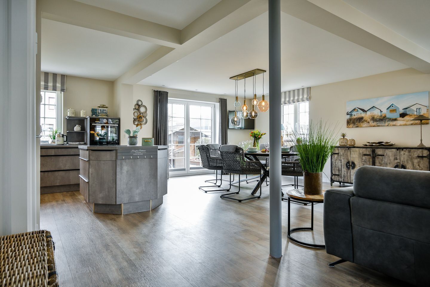 Een ruime woonkamer met keuken, eettafel en zithoek.