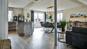 Amplia sala de estar con cocina, mesa de comedor y asientos.
