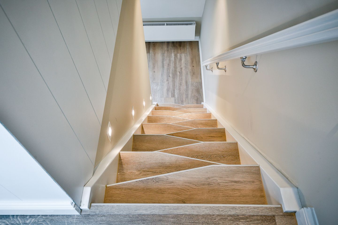 Een moderne trap met houten treden en witte wanden.