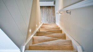 Una escalera moderna con escalones de madera y paredes blancas.