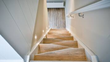 Een moderne trap met houten treden en witte wanden.