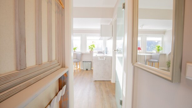 A modern kitchen with white cabinets, a sink, and a window with plants. - Sylt Like - Modernes Appartement in Zentraler Lage für bis zu Zwei Personen (Sylt)