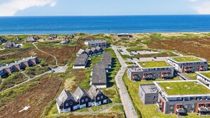 Zona residencial costera con casas, un estacionamiento y vista al mar.