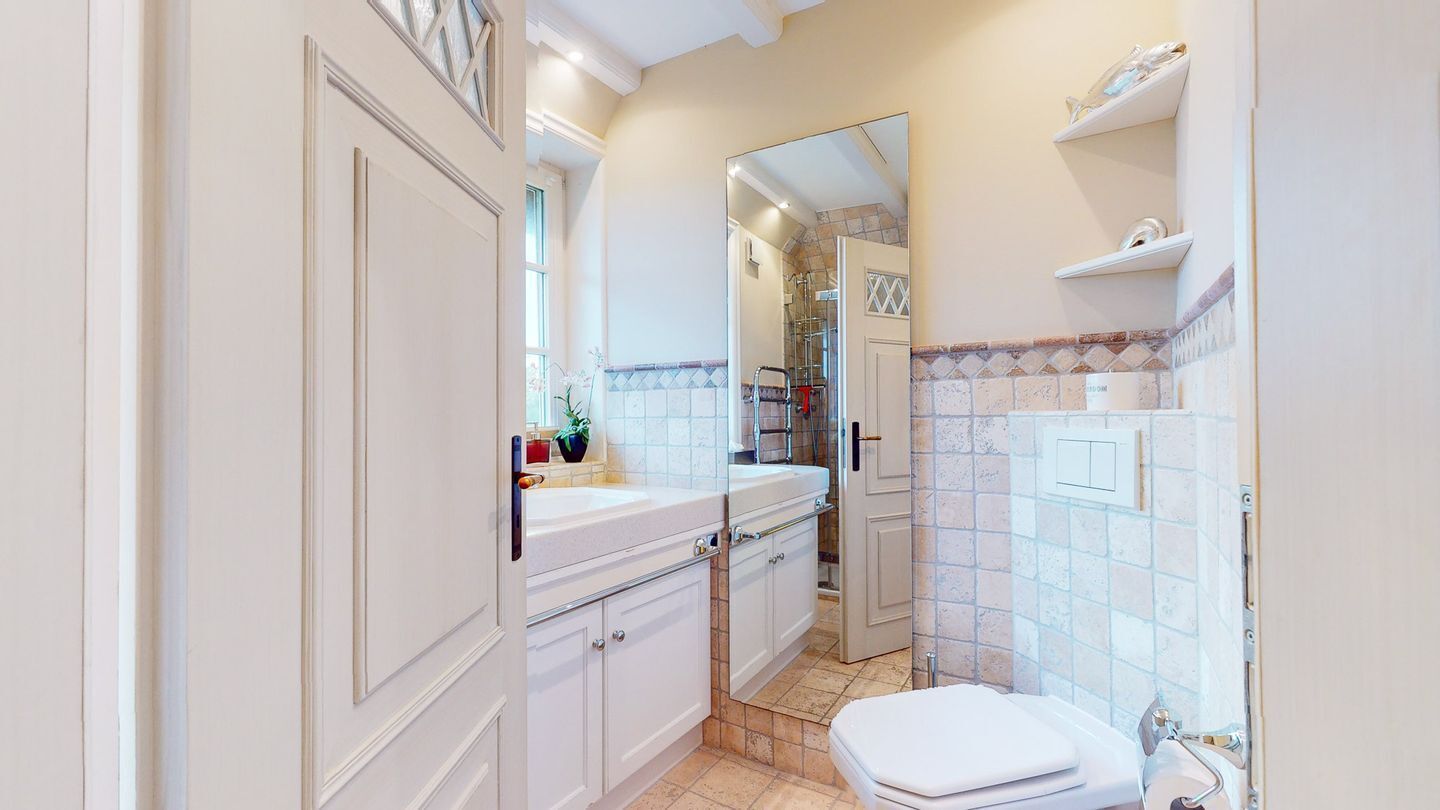 Une petite salle de bain comprenant des toilettes, un lavabo et un espace douche.