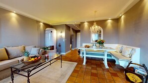 A living room with a sofa, coffee table, and a dining area with a table and chairs.