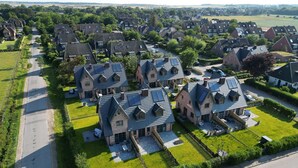 A residential area with houses featuring pitched roofs and solar panels.