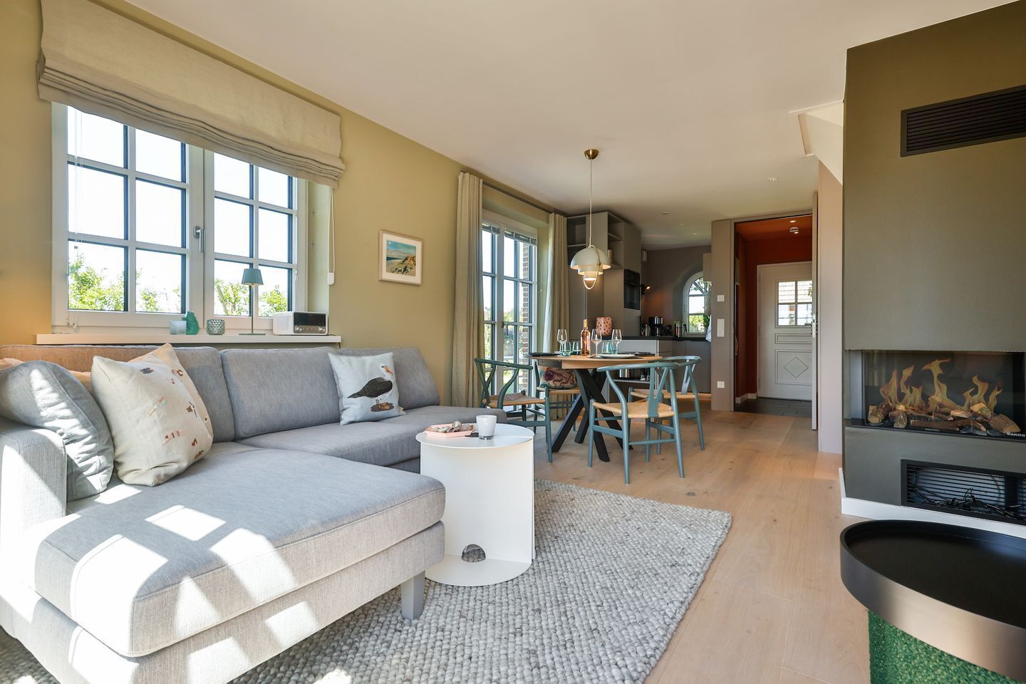 Un salon moderne avec un canapé gris, une table basse ronde et une cheminée.