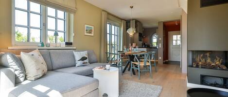 Un salon moderne avec un canapé gris, une table basse ronde et une cheminée.